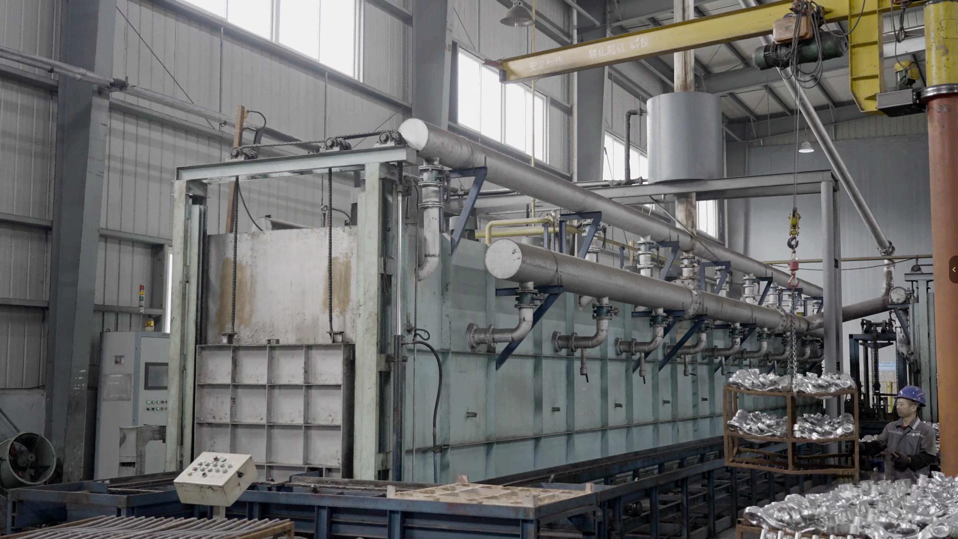Heat treatment furnace line with a worker loading baskets